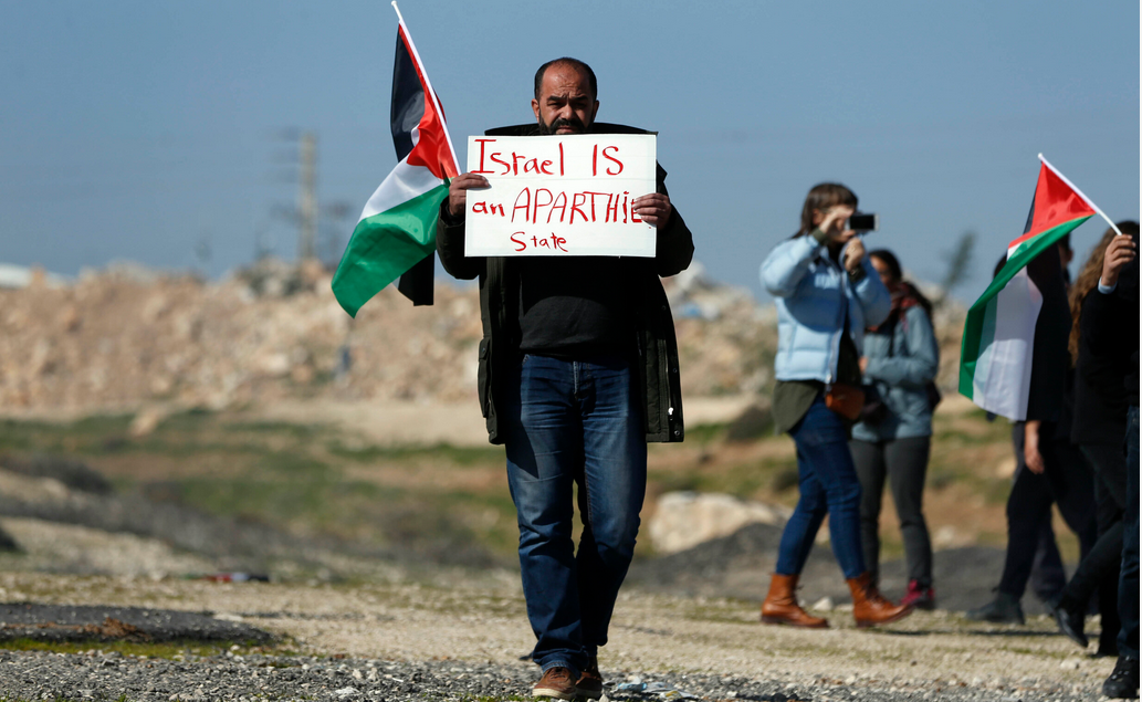 palestinian holding a plac sighn