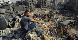 Man sitting looking at a city that has beeen destroyed