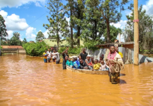 Group of people crossing a flooded area on a boat