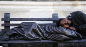 Homeless people sleeping outside on a bench