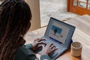 A woman sitting at a table using laptop computer.