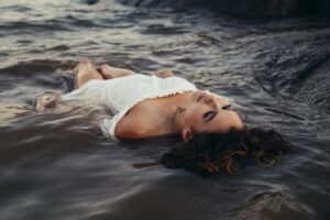 Woman flooting on water with cloths on