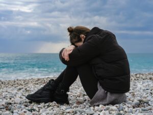 A woman by the beach struggling with mental health