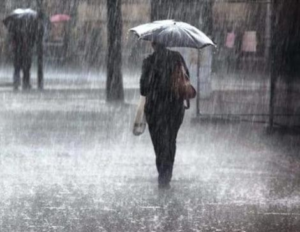 A lady walking while covering herself with an umbrella