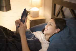 Woman using their tablet to watch movies in the bedroom at night