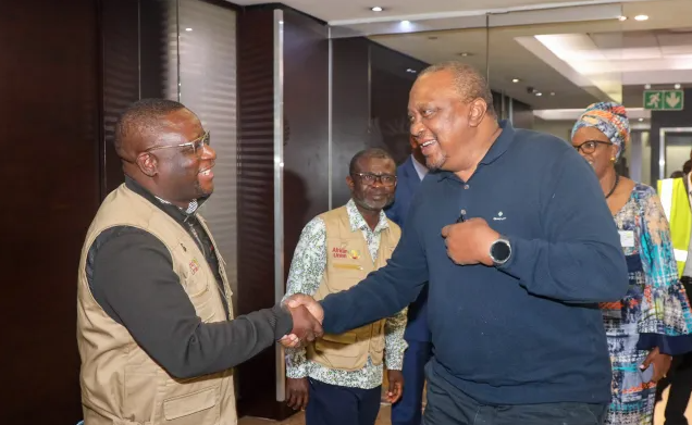 Uhuru Kenyatta greeting a polling station officer