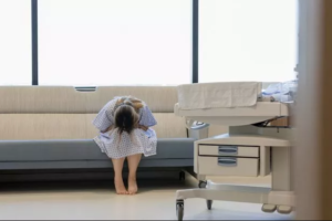 A woman in a hospital holding her stomach