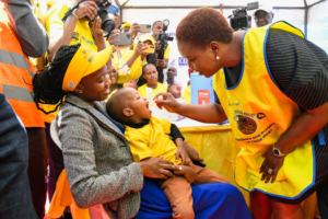 Social health worker administering vacine to a child